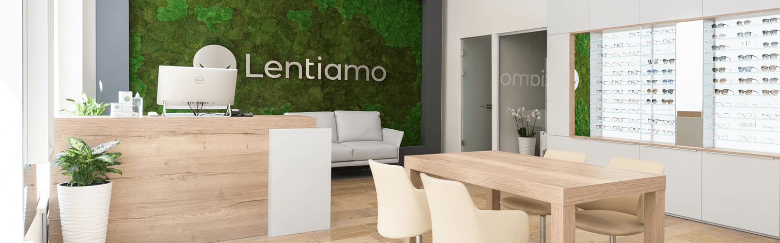 moodne optikakauplus prillide väljapaneku ja rohelise samblaga seina taustal